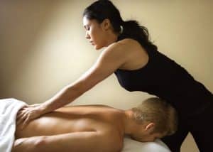 massage therapist during session with man on table