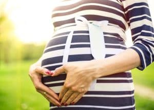 woman holding her belly during maternity photoshoot